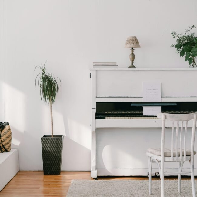 learning to play the piano later in life and image of a white piano in a well lit room