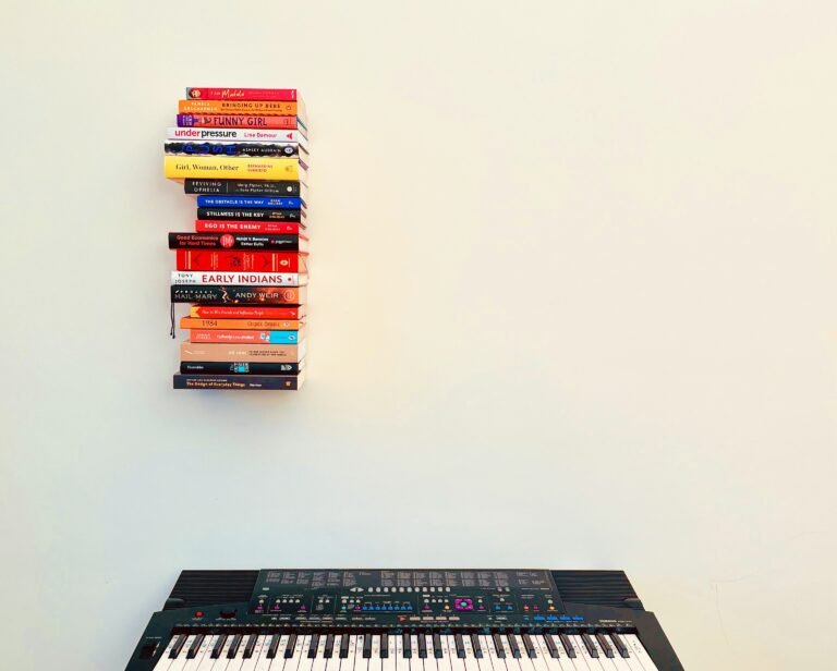 Keyboard beneath stacked colorful books