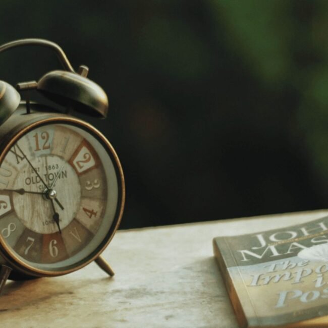 Vintage clock beside motivational book
